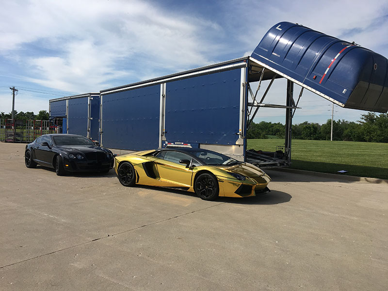 Two sports cars ready to be transported with an enclosed trailer