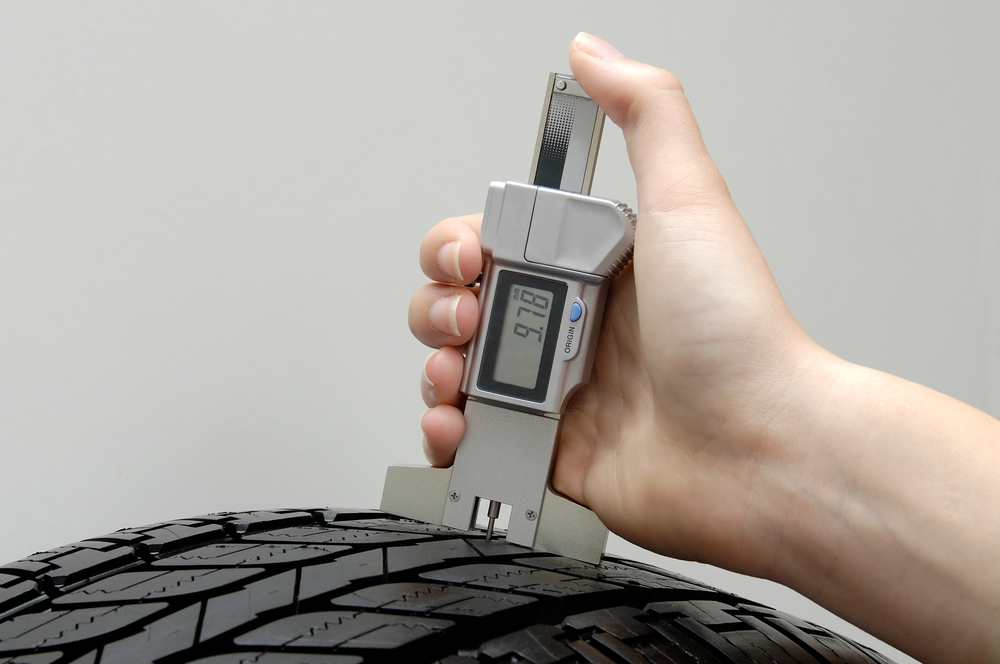 Using a tire tread gauge on a tire